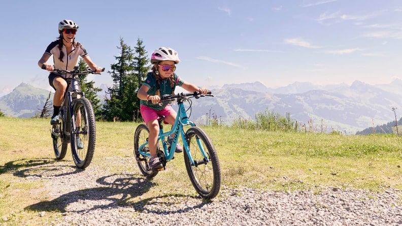 Eine Frau und ein Mädchen sind mit ihren Bikes unterwegs.