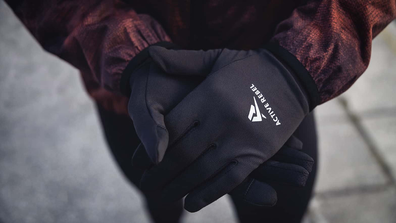 Nahaufnahme von Händen mit schwarzen Active Rebel Laufhandschuhen.