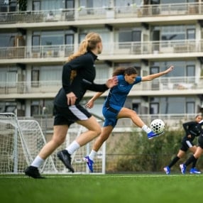 Zwei Fußballerinnen zeigen vollen Einsatz im Spiel.