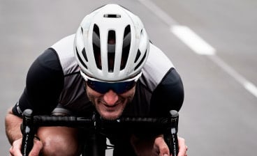 Rennradfahrer auf der Straße mit MET Fahrradhelm in weiß