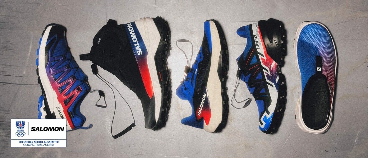 Eine Kollektion bunter Salomon-Schuhe auf einem grauen Betonboden ausgestellt.