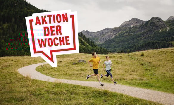 Zwei Läufer beim Laufen auf einem Bergweg vor Alpenpanorama mit dem Text Aktion der Woche.