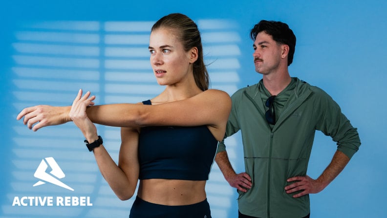 Eine Frau dehnt sich in Sportkleidung neben einem Mann.