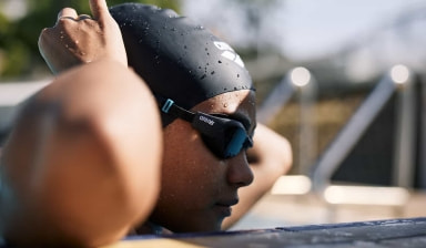 Eine Schwimmerin kontrolliert den Sitz ihrer Schwimmbrille in Vorbereitung auf ihr Training.