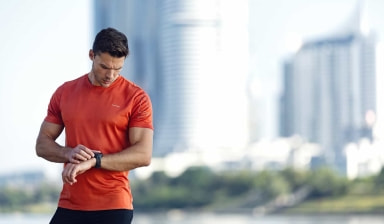 Ein Läufer checkt seine smarte Trainingsuhr.