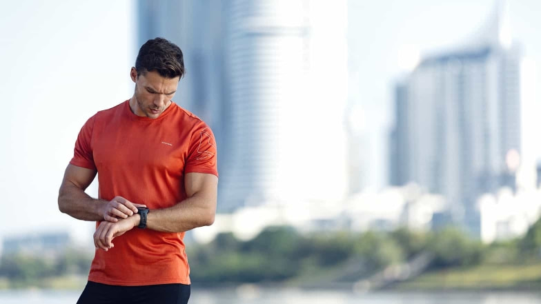 Ein Läufer checkt seine smarte Trainingsuhr.