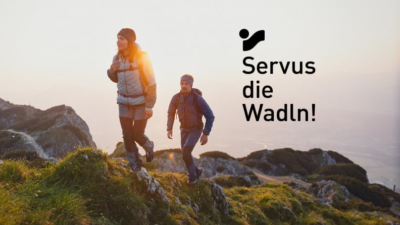 Mann und Frau wandern bei Sonnenuntergang in den Bergen.