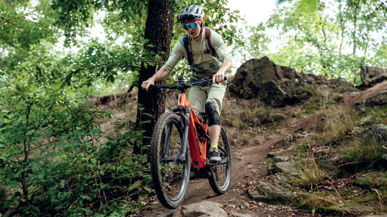 Jezdkyně na elektrokole KTM Macina Chacana 792 projíždí lesní trail v lehkém terénu.