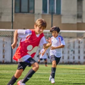 Zwei Burschen beim Fußballspiel mit gleichem Dress.