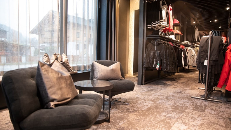 Innenansicht des INTERSPORT Gerhardter Reiteralm Shops – eine gemütliche Sitzecke am Fenster für eine kurze Pause beim Shopping.