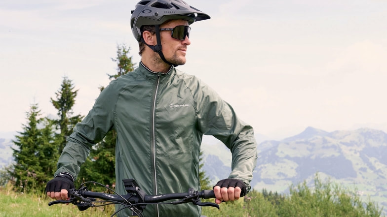 Ein Mann mit Fahrradhelm und Jacke.