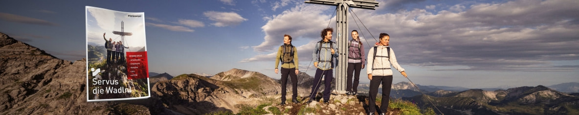 Das Titelblatt des INTERSPORT Outdoor-Special 2025. Im Hintergrund ein Bild von einem Berggipfel mit einer Wandergruppe.