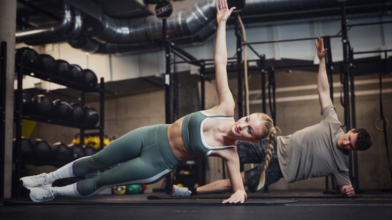 Eine Frau und ein Mann machen Side Planks.
