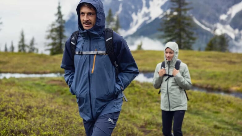 Muž a žena na horské túře v deštivém počasí.