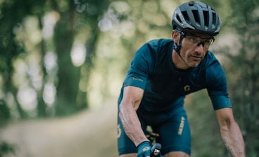 Ein konzentrierter Grabelbiker fährt mit dem Fahrrad in einem Wald.