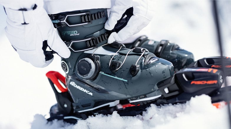 Eine Person mit Handschuhen stellt einen Skischuh mit einer BOA Bindung fest.