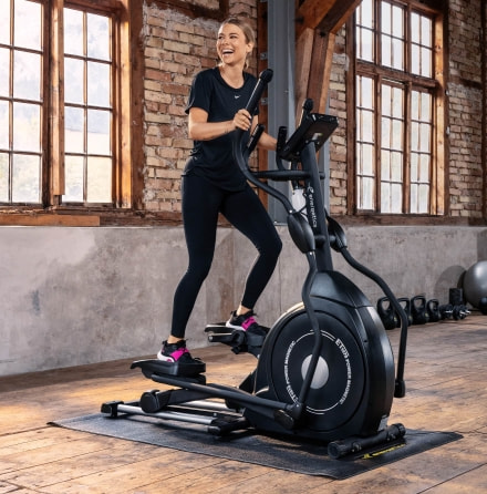 Eine Frau trainiert auf einem Crosstrainer.