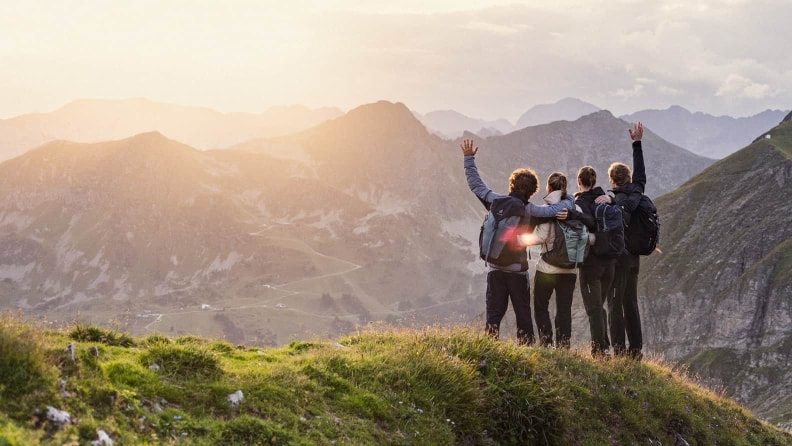 Eine Gruppe Wanderer genießt die Aussicht oben am Berg.