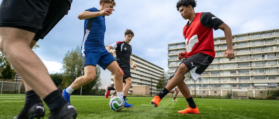 Zwei Fußballspieler kämpfen auf einem Fußballplatz in der Stadt um den Ball.