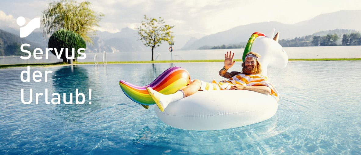 Der Sommer (Mann mit Bart und luftigem, gelbgestreiftem Umhang) entspannt auf einem aufblasbaren Einhorn im Pool mit Bergblick.
