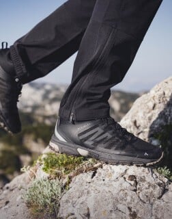 Nahaufnahme von Wanderschuhen auf felsigem Untergrund in den Bergen.
