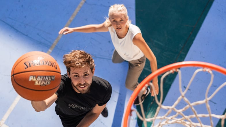 ein Mann und eine Frau beim Basketball spielen