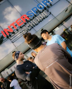 Einige Läufer stehen vor einem INTERSPORT Tscherne Geschäft beim Salomon Gravel Through Austria Community Run.