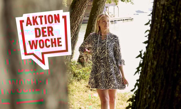 Blonde Frau steht am Seeufer und trägt eine Capricio Mili Tunika im Zebra-Look.