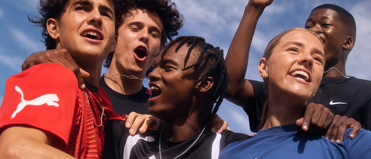 Eine vielfältige junger Leute jubelt zusammen im Freien.