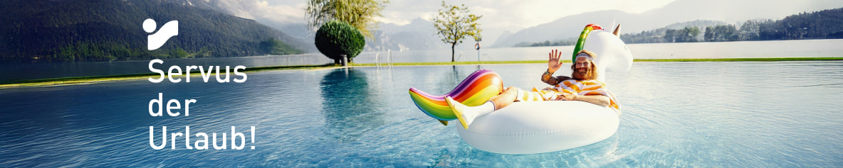 Der Sommer (Mann mit Bart und luftigem, gelbgestreiftem Umhang) entspannt auf einem aufblasbaren Einhorn im Pool mit Bergblick.
