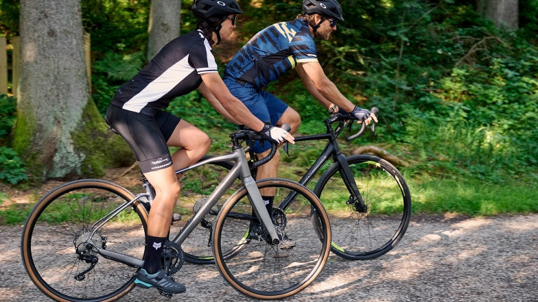 Ein Mann und eine Frau fahren Fahrrad auf einem Waldweg.