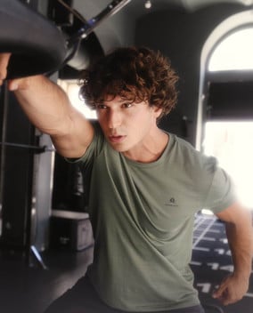 Mann trainiert an einem Fitnessgerät in einem Innenraum.