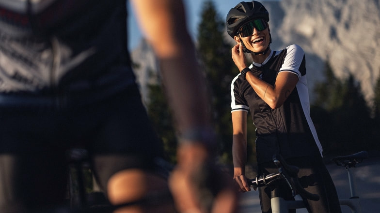 Eine Rennradfahrerin überprüft den Sitz ihres Helms vor dem Start der Tour.