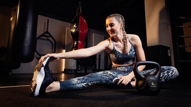 Frau beim Dehnen im Fitnessstudio.