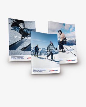 Die drei Garantie- und Leistungspässe Winter von INTERSPORT liegen nebeneinander auf weißem Hintergrund.