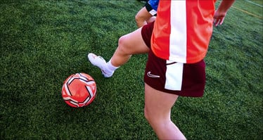 Nahaufnahme einer Fußballspielerin im Einsatz.