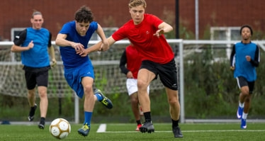 Zwei Fußballspieler versuchen vor dem jeweils anderen an den Ball zu kommen.