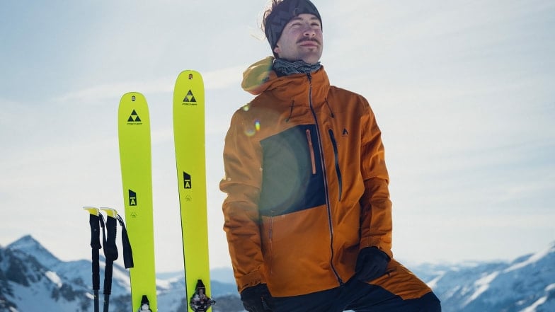 Ein Mann mit Skiern genießt die Sonne in den Bergen.