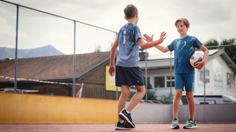 Zwei Jungen begrüßen sich mit einem Handschlag vor ihrem Fußballspiel.