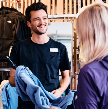 Ein INTERSPORT Mitarbeiter berät eine Kundin im Shop.