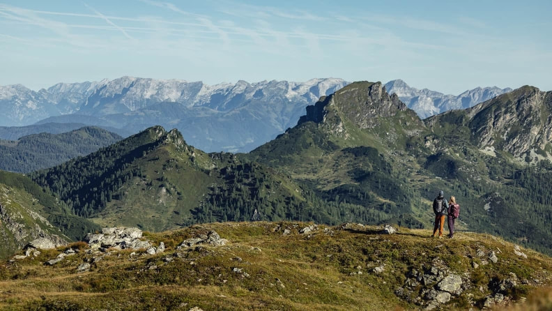 Eine Gebirgskette und zwei Wanderer.