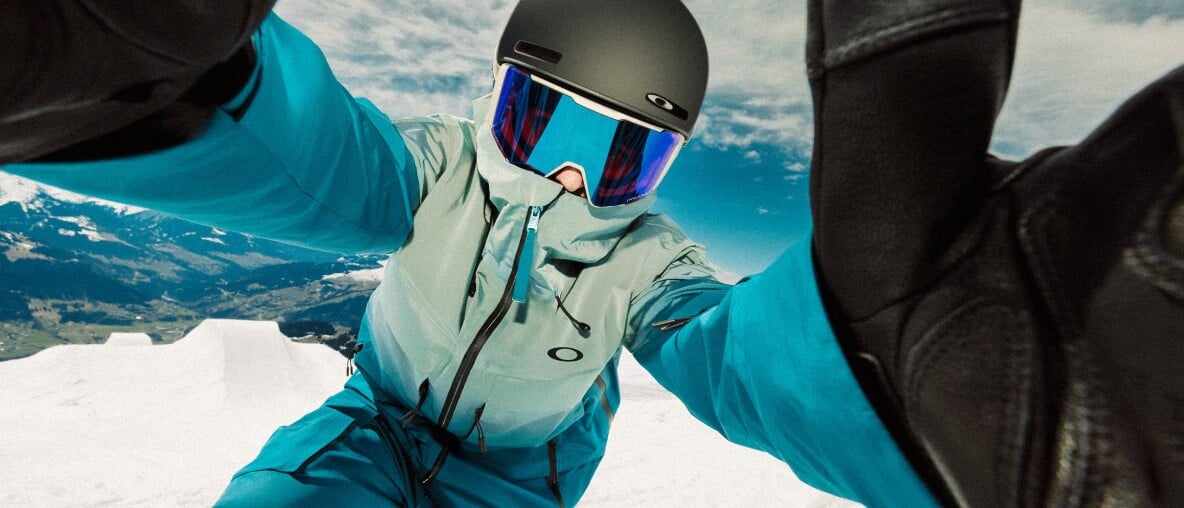 Eine Skifahrerin in voller Montur macht ein Selfie im Schnee.