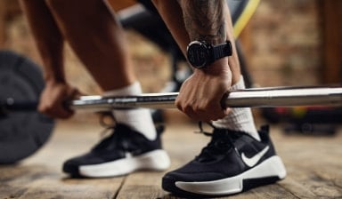Ein Mann hebt eine Langhantel beim Training im Fitnessstudio.