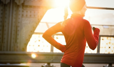 Eine Frau in roter Sportkleidung läuft am Abend.