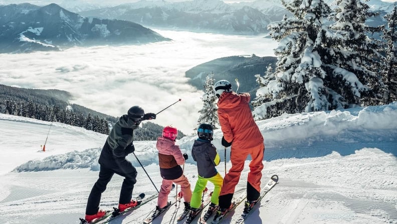 Eine Familie beim Skifahren genießt die Aussicht in den Bergen.