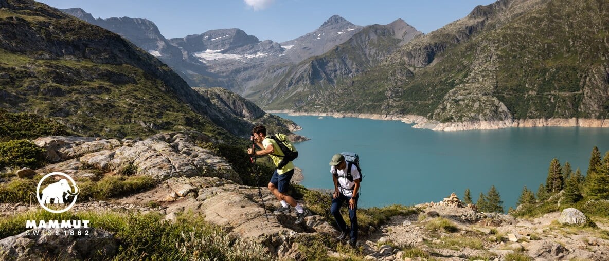 Wanderer in den Bergen – im Hintergrund ein türkisblauer See.