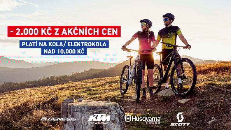 Muž a žena na horách drží kola Genesis Impact Carbon. Na levo je nadpis akce: - 2000 Kč z akční ceny. Dole jsou pak loga značek Genesis, KTM, Husqvarna a Scott