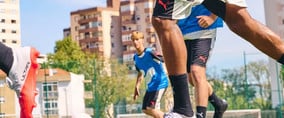 Blick auf ein Fußballspiel – einige Spieler laufen vorbei.