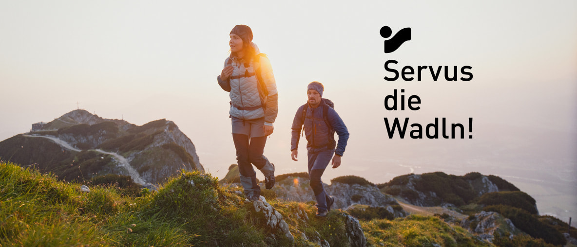 Mann und Frau wandern bei Sonnenuntergang in den Bergen.
