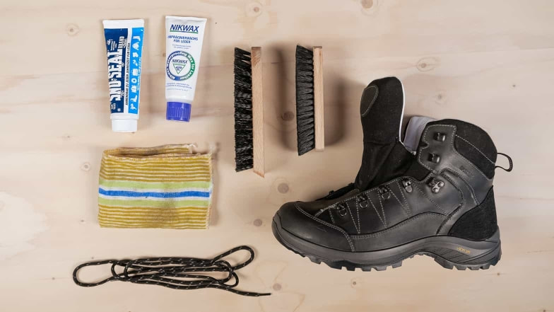 Alles für die Pflege des Wanderschuhs liegt bereit: Schuhwachs, Tuch und Bürste.